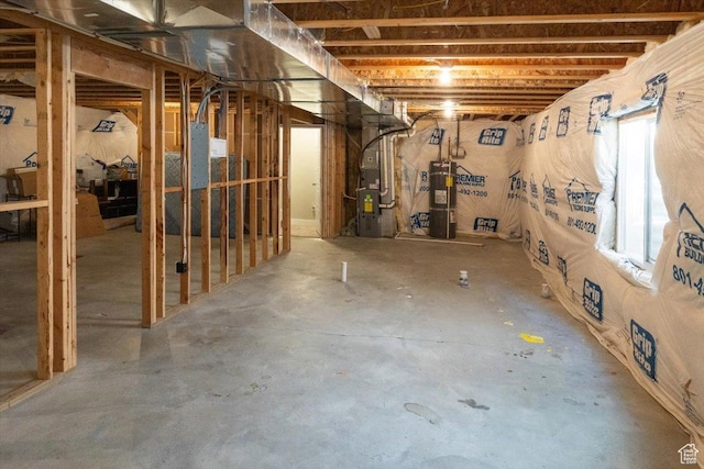 basement featuring heating unit and strapped water heater