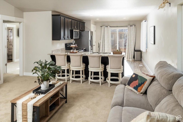 living room featuring light colored carpet and sink