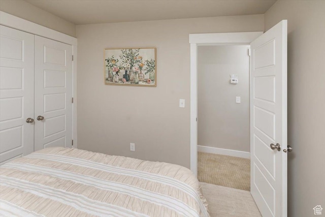 bedroom with light carpet and a closet