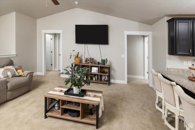 carpeted living room with ceiling fan and vaulted ceiling