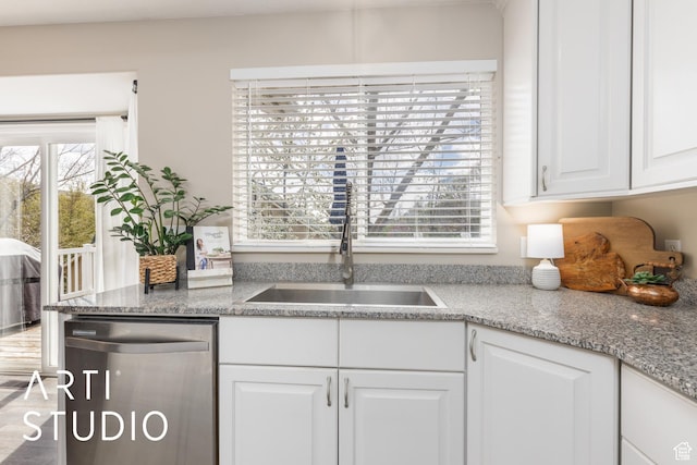 kitchen featuring dishwasher, light stone countertops, white cabinetry, and a sink