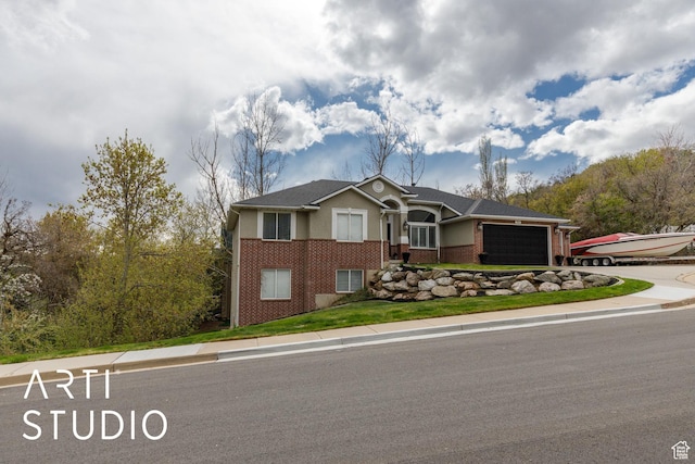 view of front of house with stucco siding, brick siding, driveway, and a garage