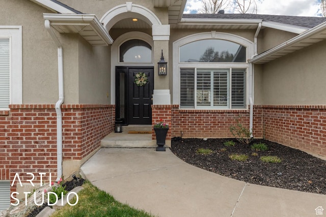 property entrance featuring brick siding and stucco siding