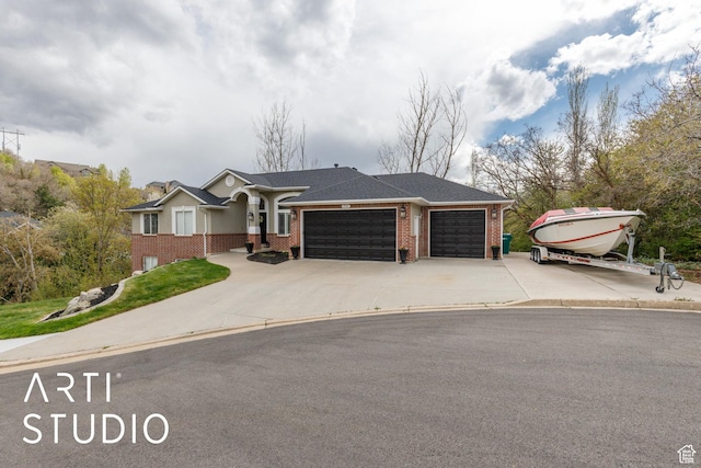 view of front facade featuring brick siding, an attached garage, and concrete driveway