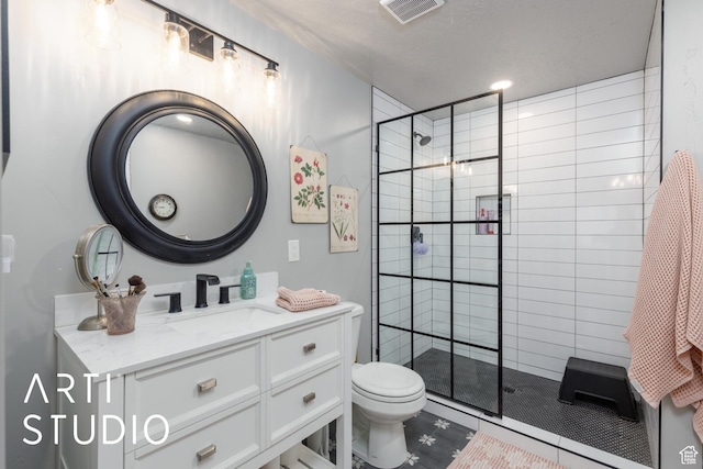 full bath featuring a tile shower, toilet, vanity, and visible vents
