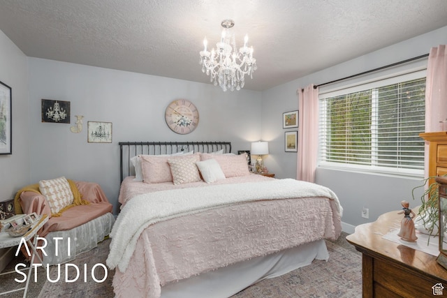 bedroom featuring a chandelier, a textured ceiling, and baseboards