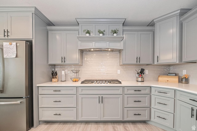 638 E Canyon Rim Rd N, Smithfield, UT 84335 - kitchen featuring gray cabinetry, premium range hood, appliances with stainless steel finishes, and tasteful backsplash