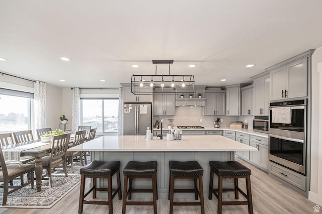 638 E Canyon Rim Rd N, Smithfield, UT 84335 - kitchen featuring a center island with sink, gray cabinetry, light wood-type flooring, and stainless steel appliances