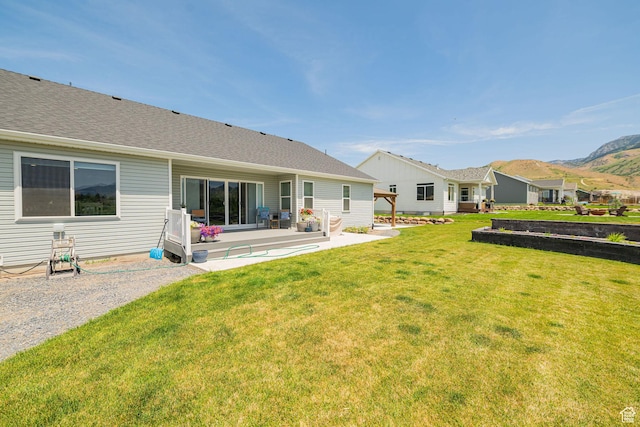 638 E Canyon Rim Rd N, Smithfield, UT 84335 - rear view of house featuring a patio, a lawn, a shingled roof, and a mountain view