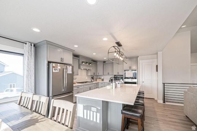 638 E Canyon Rim Rd N, Smithfield, UT 84335 - kitchen with stainless steel appliances, backsplash, pendant lighting, a breakfast bar area, and gray cabinets