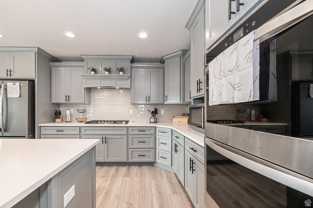 638 E Canyon Rim Rd N, Smithfield, UT 84335 - kitchen with gray cabinetry, stainless steel fridge, light hardwood / wood-style floors, and backsplash