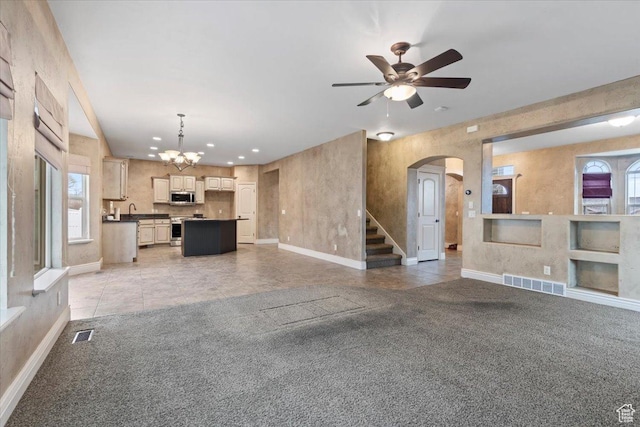 2493 S Aster Way, Saratoga Springs, UT 84045 - unfurnished living room featuring arched walkways, baseboards, visible vents, and light colored carpet