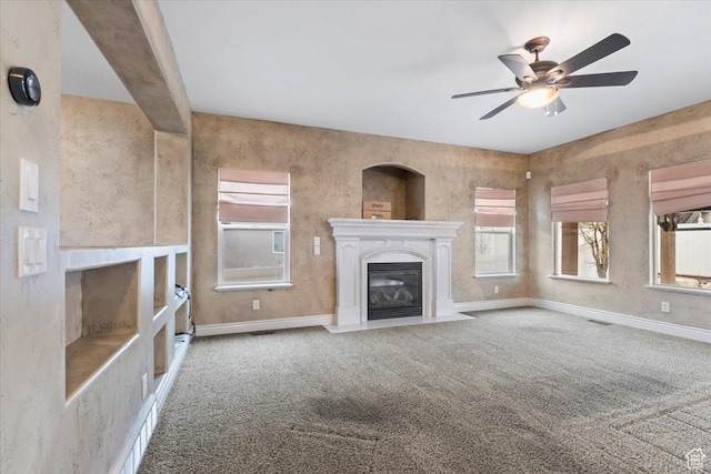 2493 S Aster Way, Saratoga Springs, UT 84045 - unfurnished living room featuring carpet, visible vents, a ceiling fan, a glass covered fireplace, and baseboards