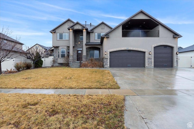 view of front of home with a balcony, fence, driveway, stucco siding, and a front lawn
