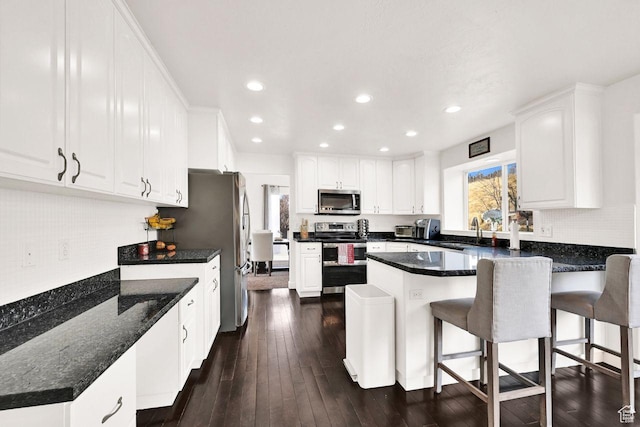 582 W 3900 N, Pleasant View, UT 84414 - kitchen with white cabinets, appliances with stainless steel finishes, a breakfast bar, and sink