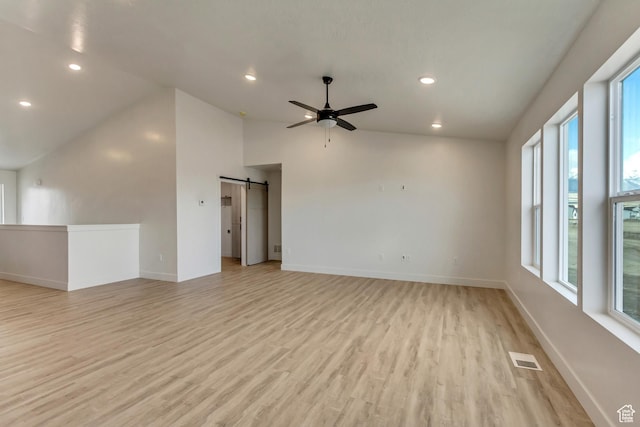 706 W Osborne Way S Unit 803, Grantsville, UT 84029 - spare room with a healthy amount of sunlight, a barn door, light hardwood / wood-style flooring, and lofted ceiling