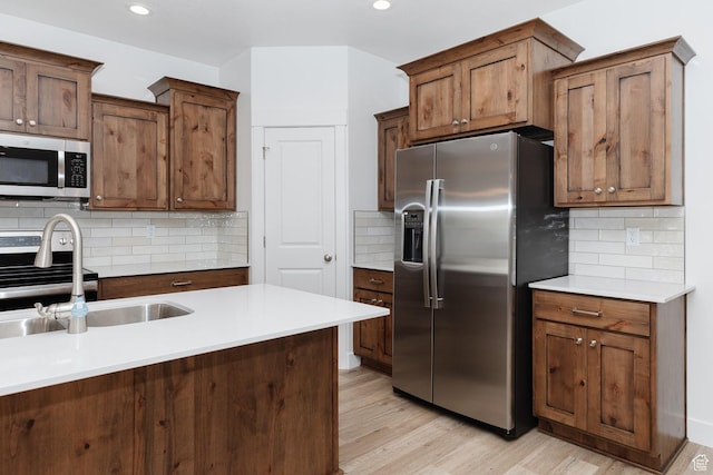 732 E 750 S, Preston, ID 83263 - kitchen with light wood-style flooring, appliances with stainless steel finishes, a sink, and backsplash