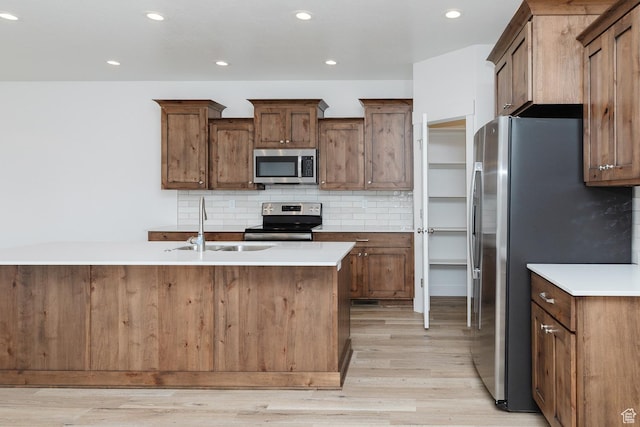 732 E 750 S, Preston, ID 83263 - kitchen with a sink, light countertops, appliances with stainless steel finishes, light wood-style floors, and decorative backsplash