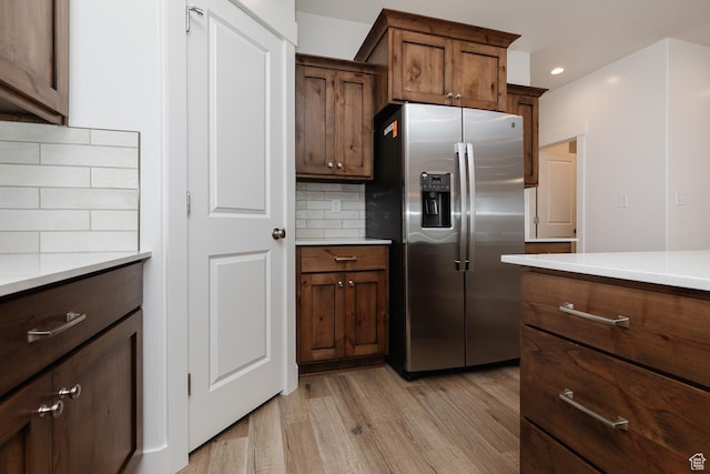732 E 750 S, Preston, ID 83263 - kitchen featuring stainless steel fridge with ice dispenser, tasteful backsplash, light wood-type flooring, recessed lighting, and light countertops