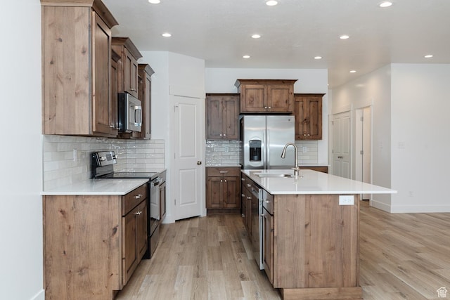 732 E 750 S, Preston, ID 83263 - kitchen featuring a sink, appliances with stainless steel finishes, light wood-style floors, and an island with sink