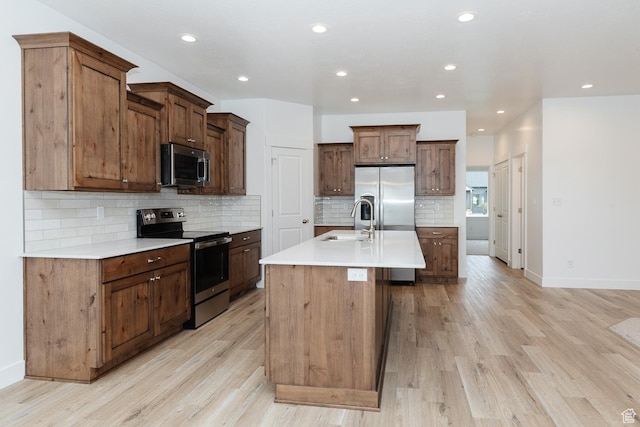 732 E 750 S, Preston, ID 83263 - kitchen with light wood-style floors, appliances with stainless steel finishes, light countertops, a sink, and backsplash