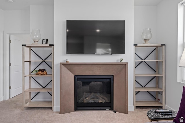 room details featuring carpet floors, baseboards, and a glass covered fireplace