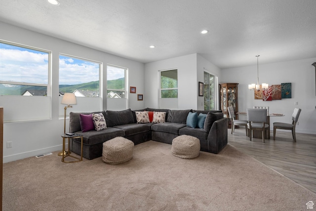 living area featuring a notable chandelier, light wood-style floors, recessed lighting, baseboards, and visible vents