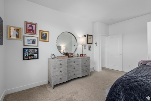 bedroom with baseboards, visible vents, and light carpet