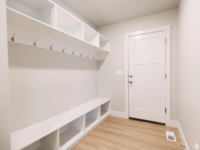 mudroom with baseboards, light wood-style flooring, and visible vents