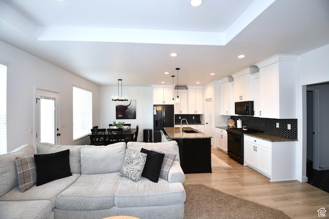 2129 N 3000 W, Plain City, UT 84404 - living room featuring recessed lighting, a tray ceiling, an inviting chandelier, and light wood finished floors