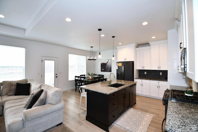 2129 N 3000 W, Plain City, UT 84404 - kitchen featuring tasteful backsplash, open floor plan, light wood-style floors, black appliances, and a sink