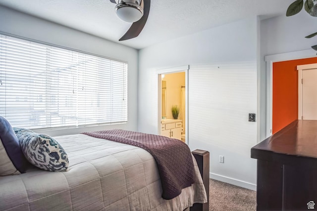 bedroom with multiple windows, ceiling fan, carpet, and connected bathroom
