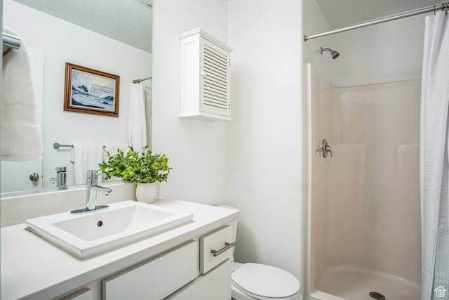 bathroom featuring a textured ceiling, curtained shower, vanity, and toilet