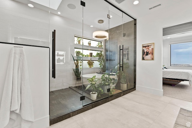 bathroom featuring a shower with shower door and a wealth of natural light