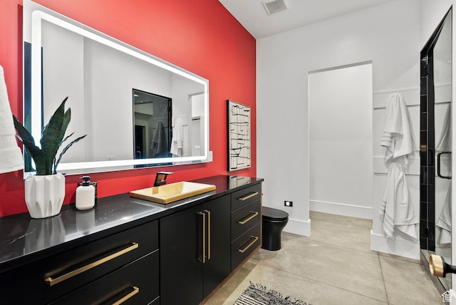 bathroom with a shower with door, vanity, and toilet