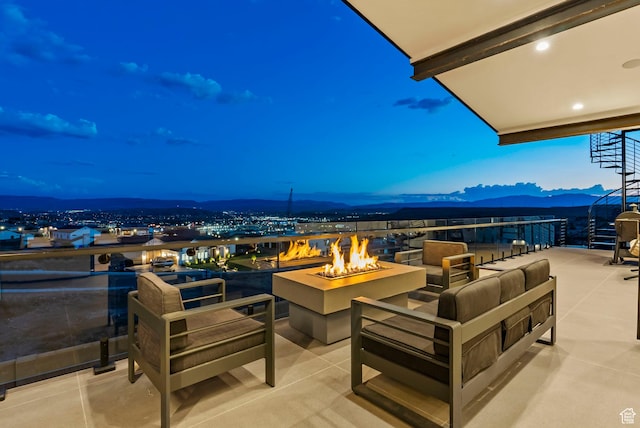 patio terrace at dusk featuring a mountain view and a fire pit
