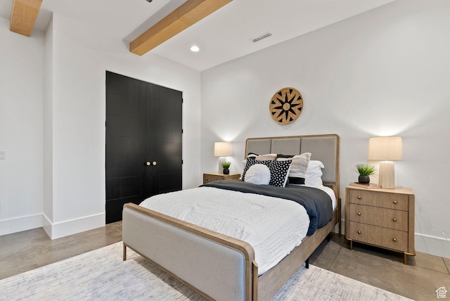 bedroom with beamed ceiling and concrete floors