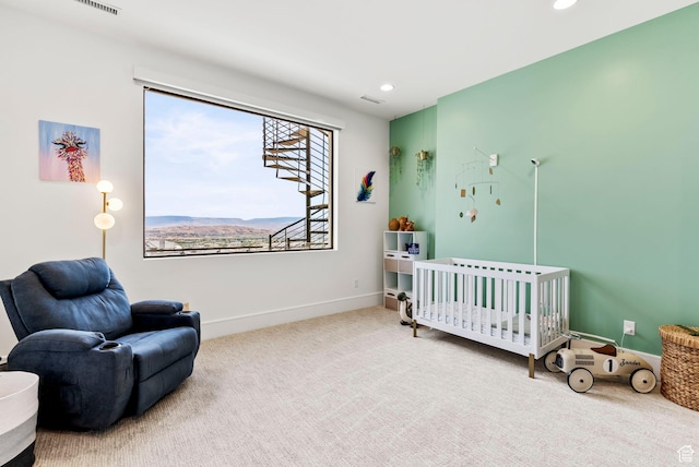 carpeted bedroom with a mountain view and a nursery area