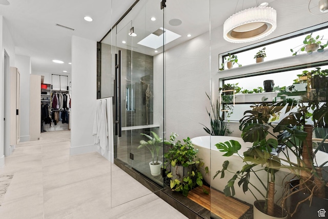 bathroom with tile patterned flooring, a skylight, and independent shower and bath