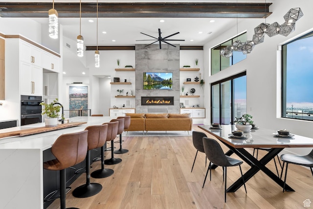 dining area featuring ceiling fan, light hardwood / wood-style floors, and a fireplace