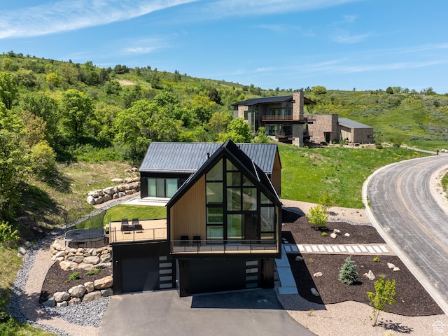 1113 S Quail Holw E, Huntsville, UT 84317 - rear view of property with driveway, an attached garage, metal roof, a view of trees, and a lawn