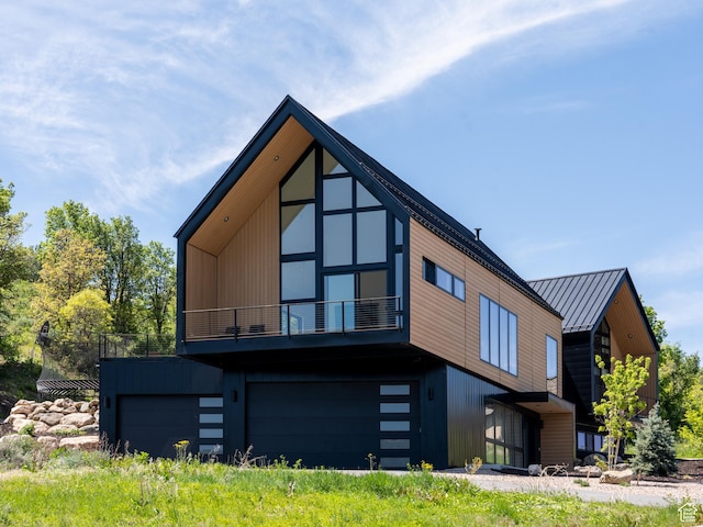 1113 S Quail Holw E, Huntsville, UT 84317 - view of front of house featuring a balcony, a standing seam roof, metal roof, and a garage