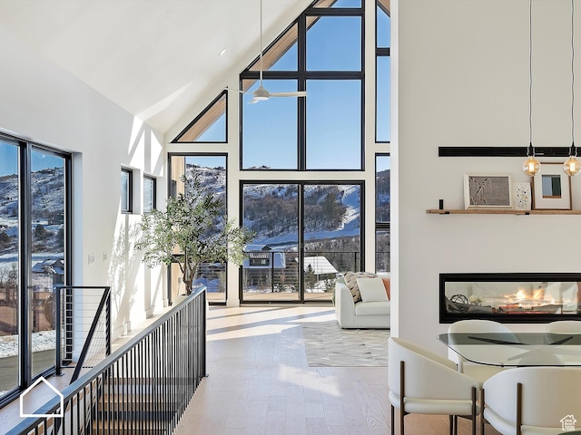 entryway with ceiling fan, high vaulted ceiling, and wood-type flooring