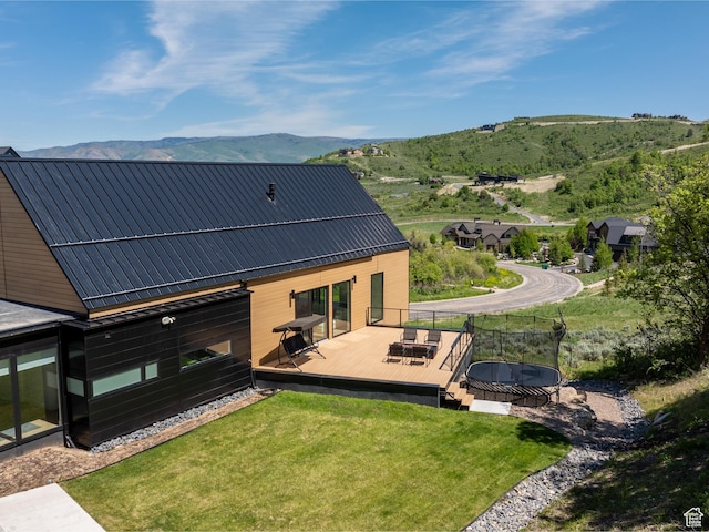 1113 S Quail Holw E, Huntsville, UT 84317 - back of property with a deck with mountain view, a lawn, and a trampoline