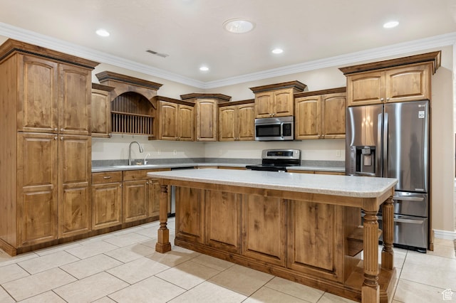 kitchen with a sink, light tile patterned floors, light countertops, appliances with stainless steel finishes, and a kitchen island