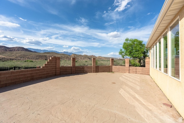 view of yard featuring fence and a mountain view