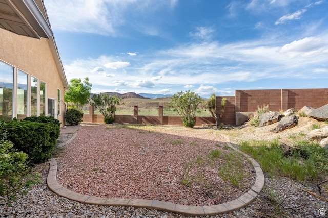 view of yard featuring a fenced backyard and a mountain view