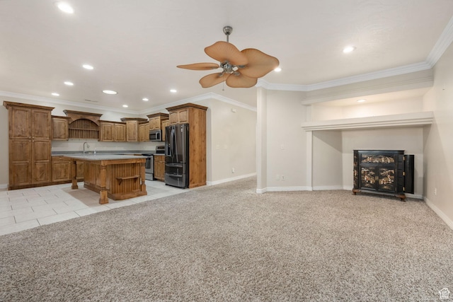 kitchen featuring open shelves, a sink, brown cabinetry, stainless steel appliances, and a fireplace