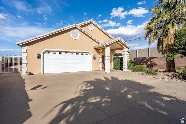 ranch-style house with fence, an attached garage, driveway, and stucco siding