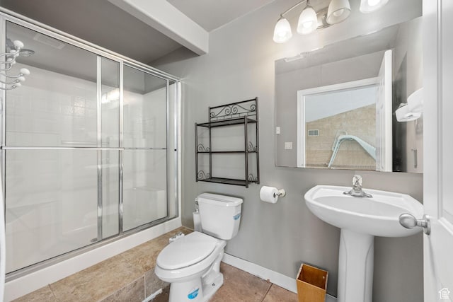 full bath with baseboards, tile patterned flooring, a shower stall, and toilet